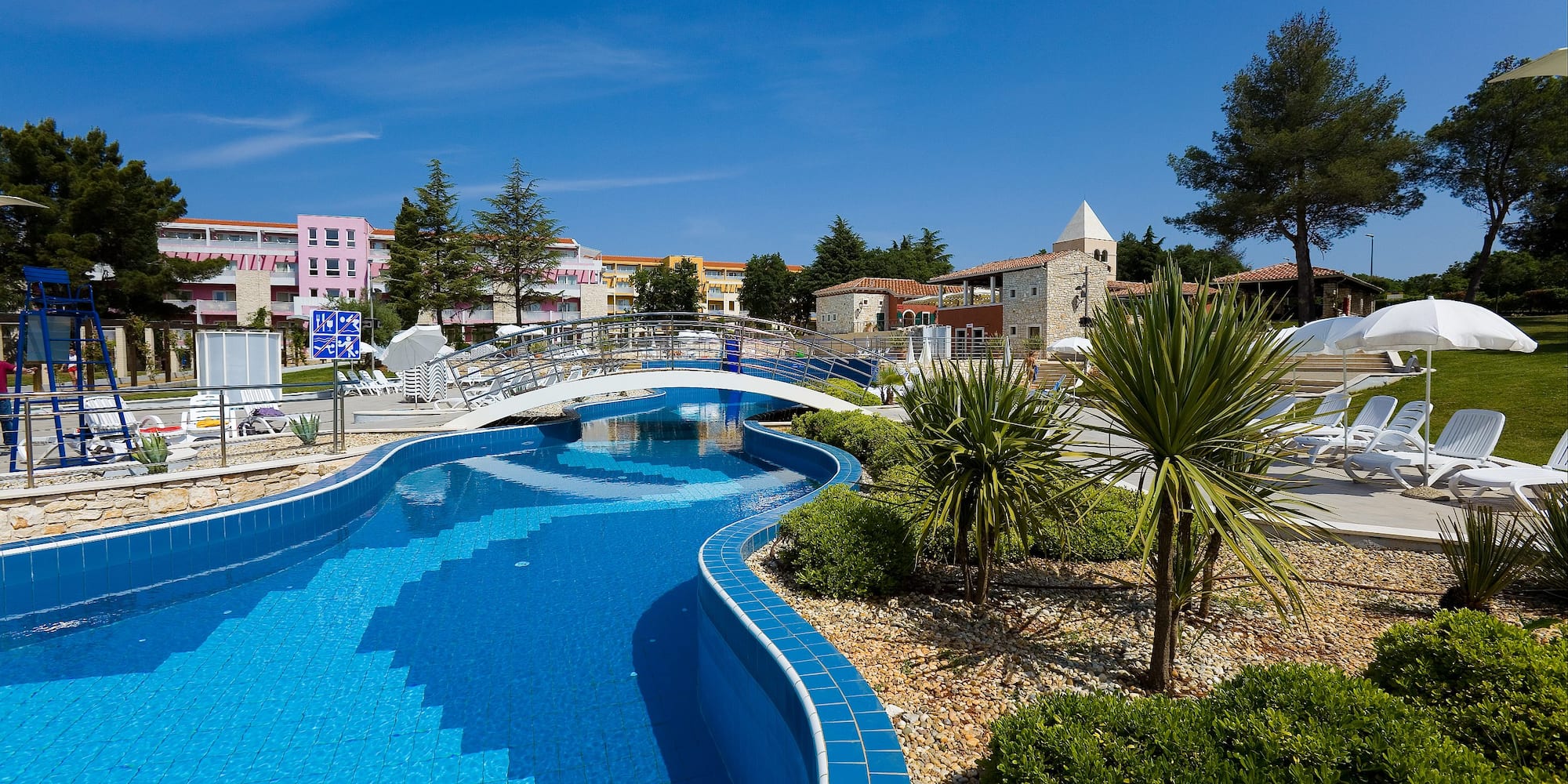 a pool with a bridge and trees