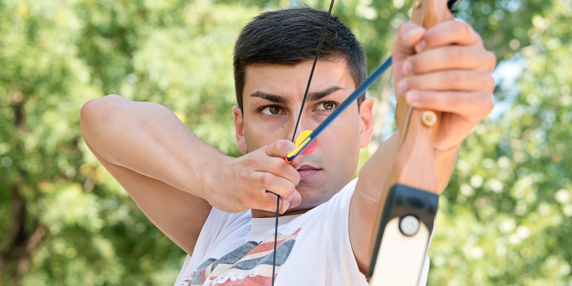 a man shooting a bow and arrow