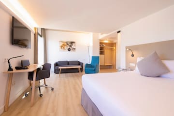 a room with a bed and a desk and chair