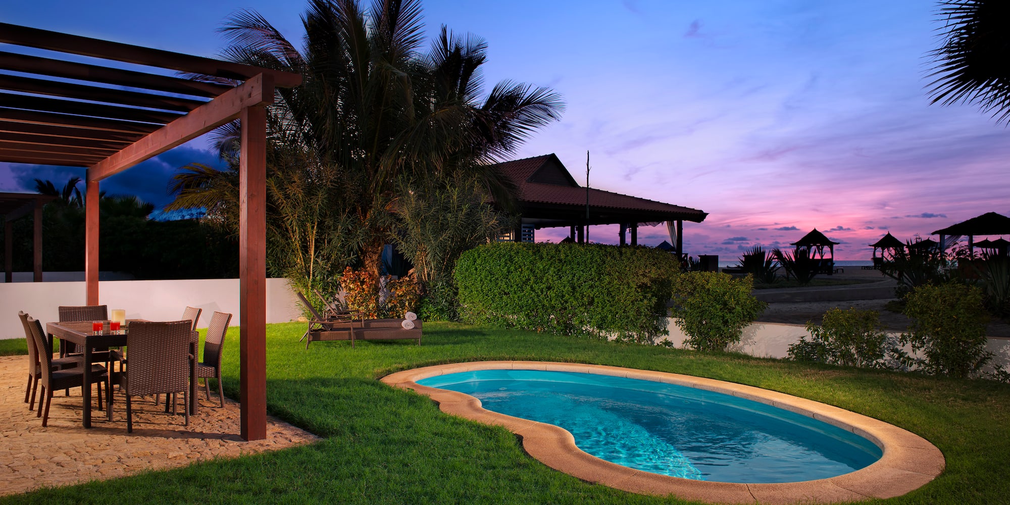 a pool with a table and chairs in a backyard