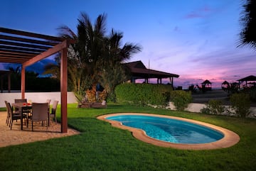 a pool with a table and chairs in a backyard