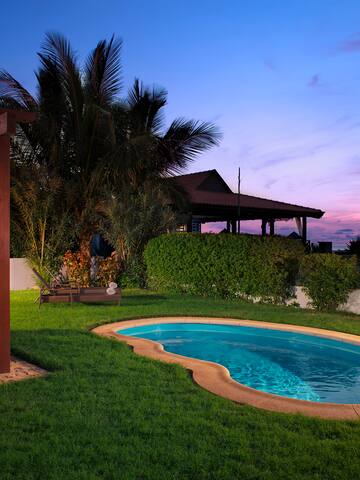 a pool with a table and chairs in a backyard