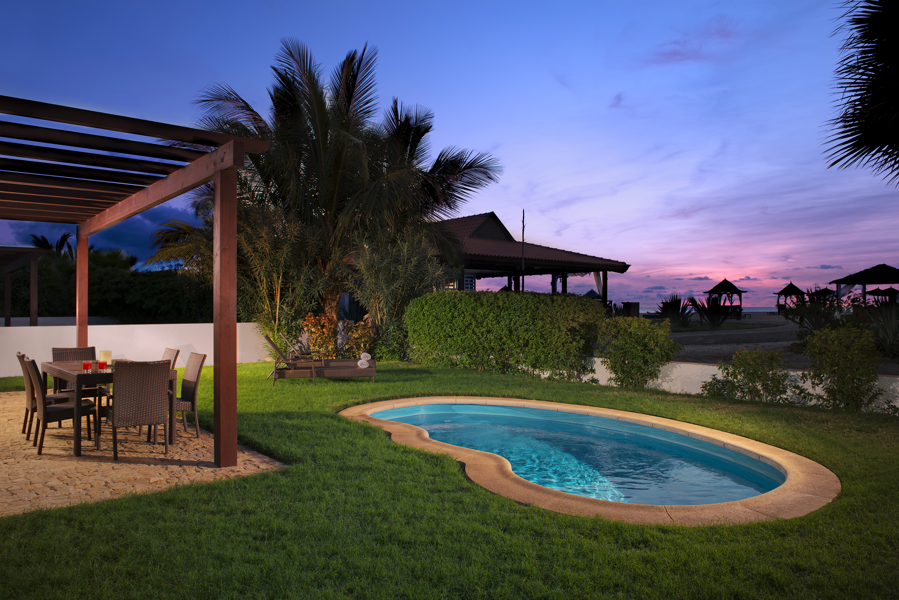 a pool with a table and chairs in a backyard