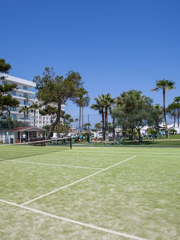 a tennis court with trees and buildings in the background