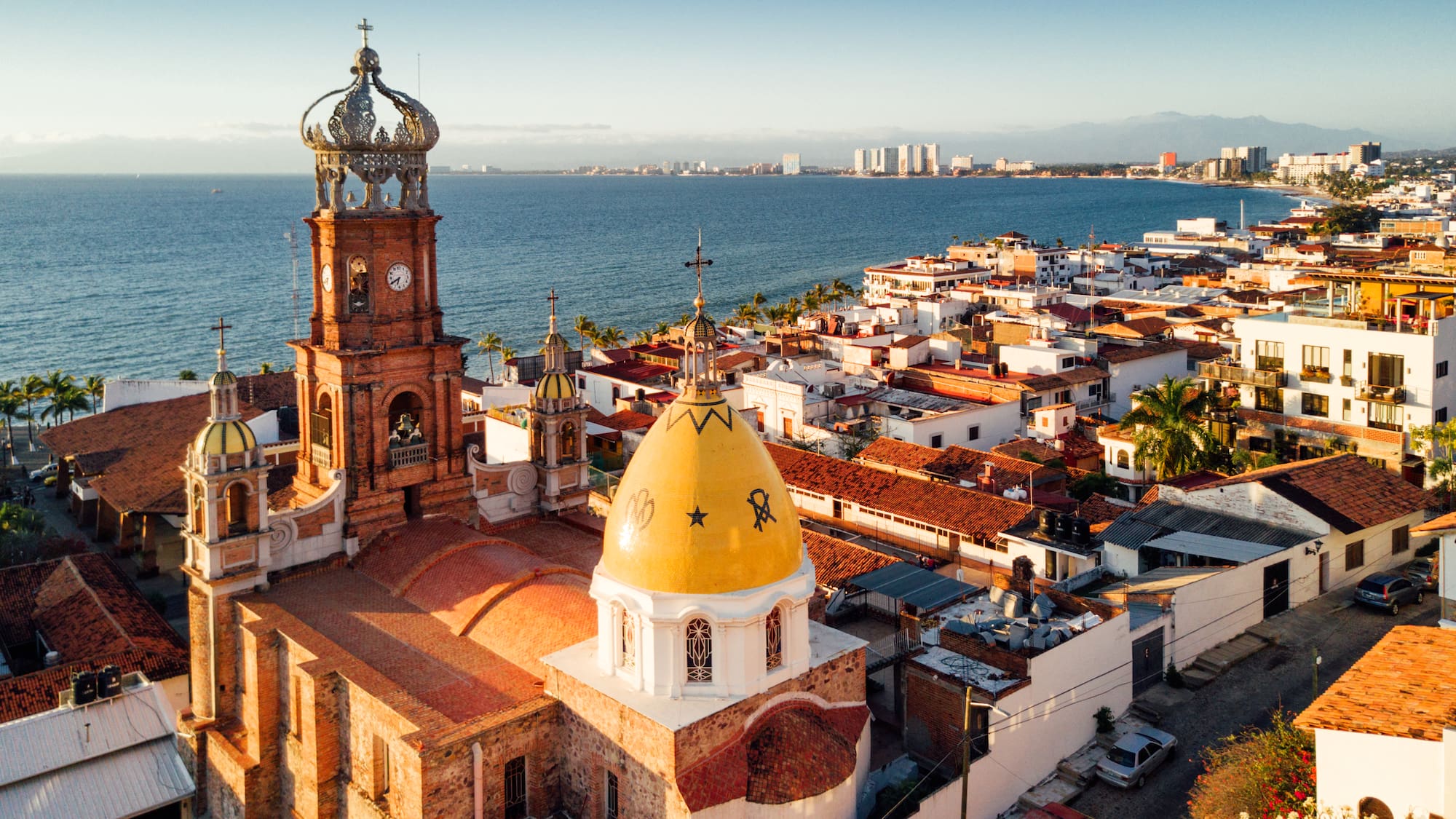 a building with a clock tower and a city by the water