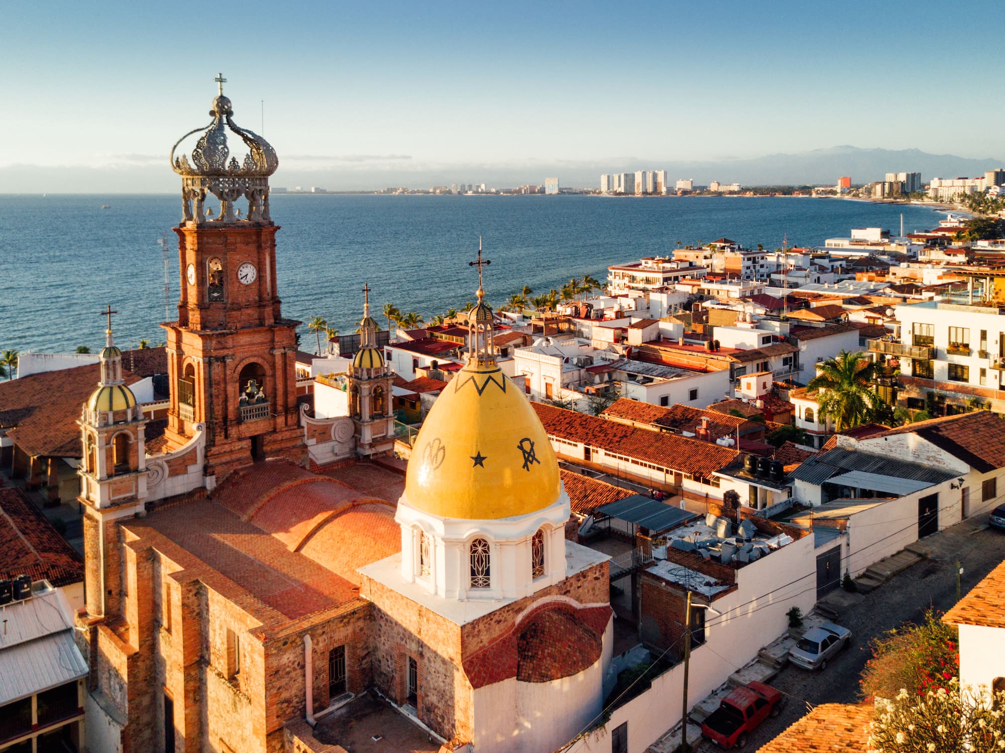 a building with a clock tower and a city by the water