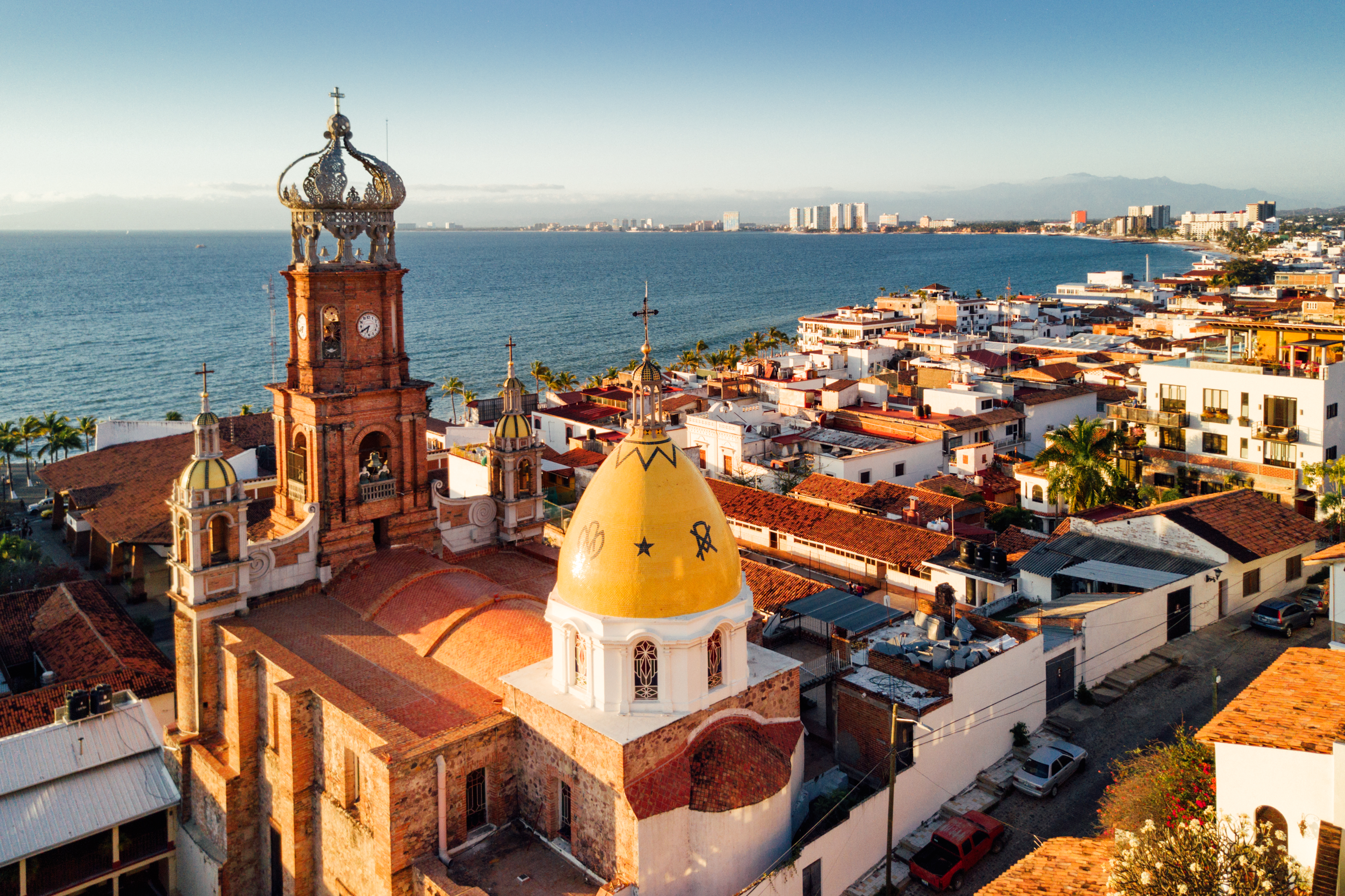 a building with a clock tower and a city by the water