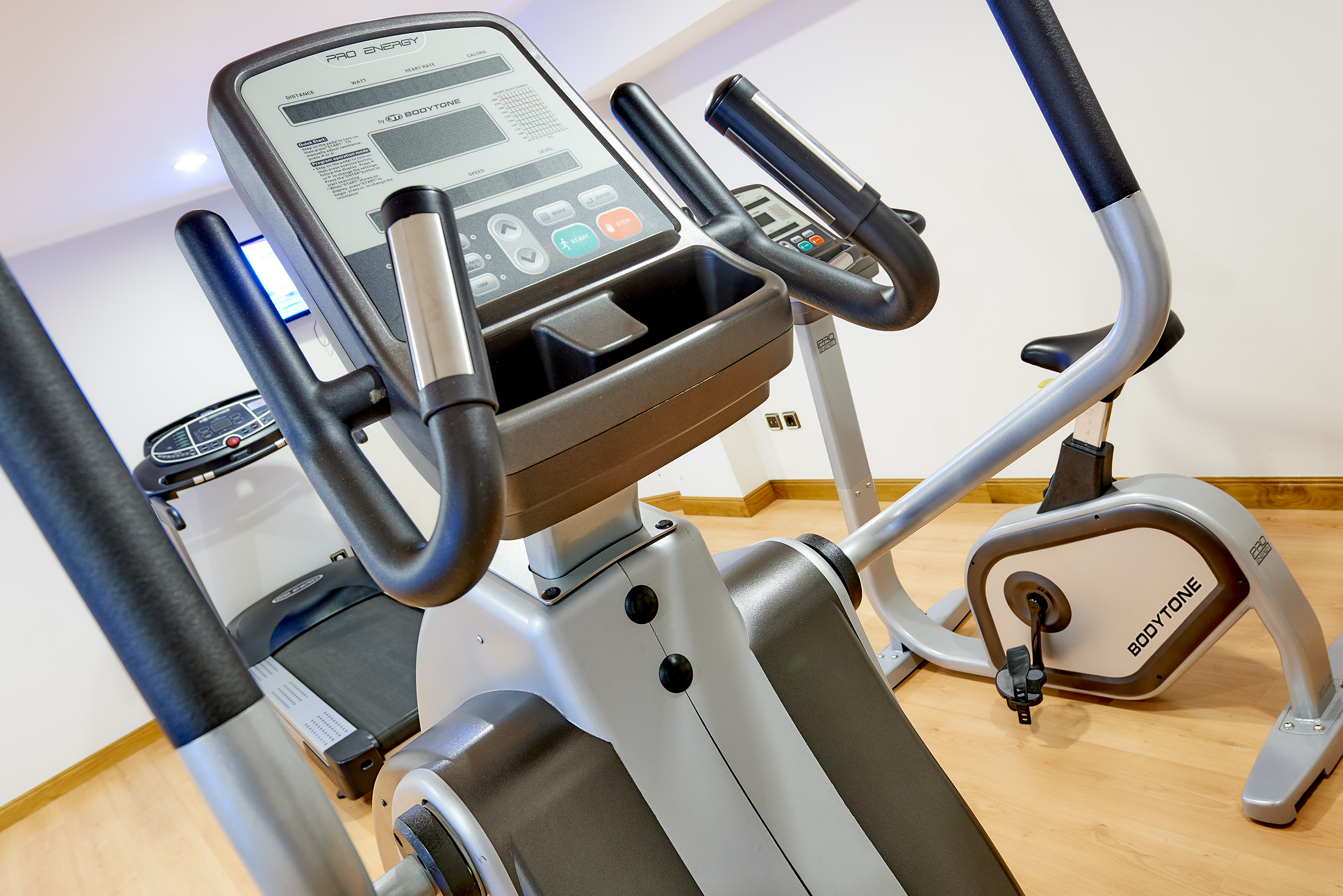 Gym with PRO ENERGY elliptical trainer, BODYTONE exercise bike, and treadmill.