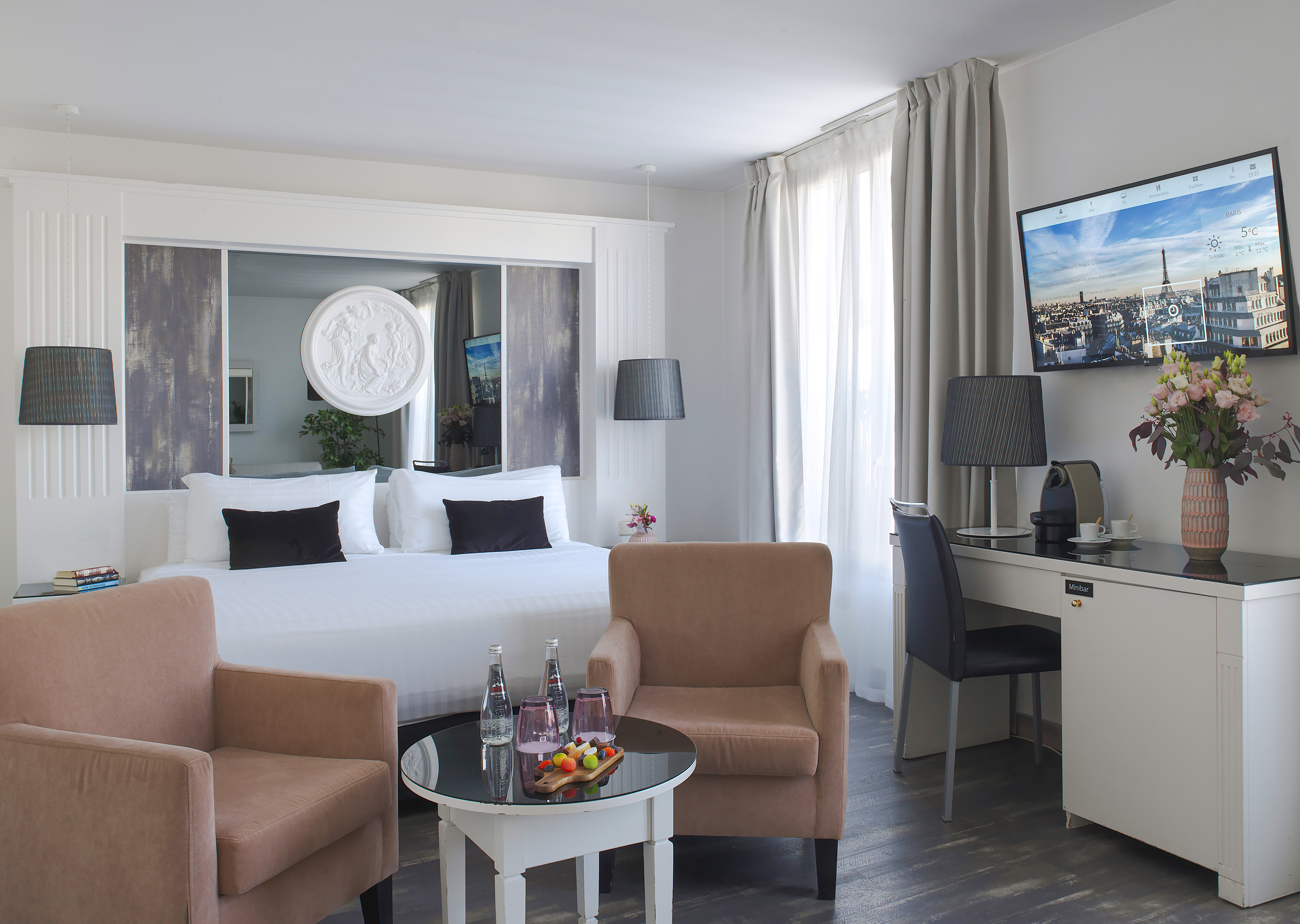 Luxurious hotel room featuring king bed, cozy seating, and modern amenities.