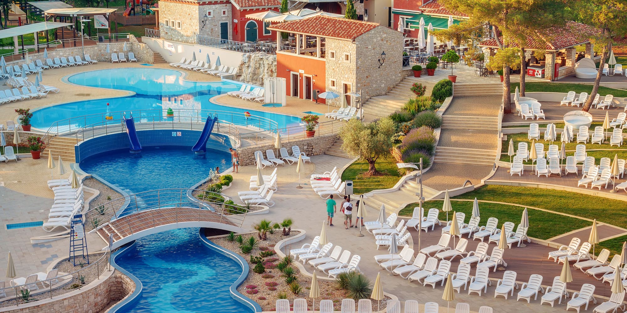a swimming pool with chairs and a pool in a resort