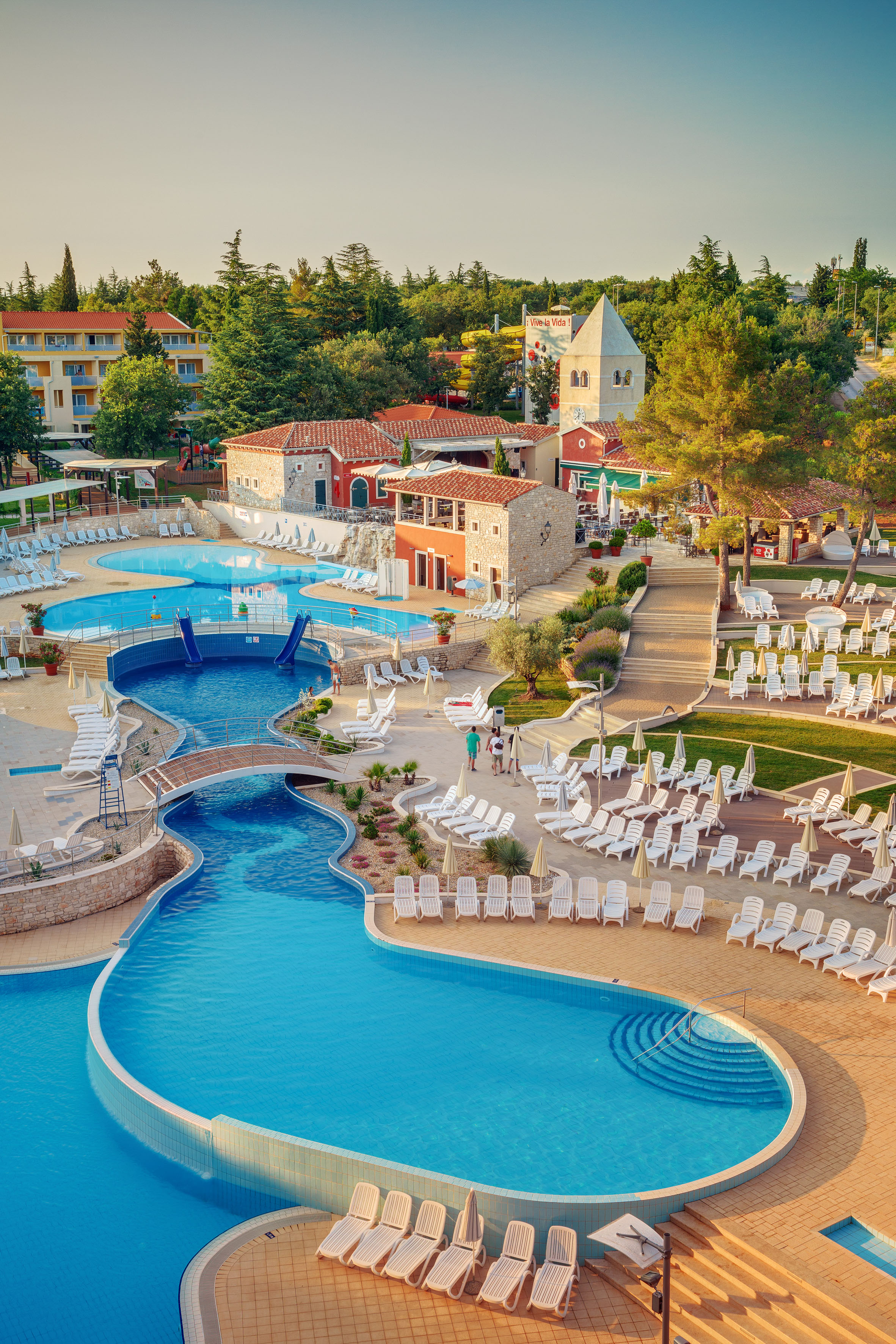 a swimming pool with chairs and a pool in a resort