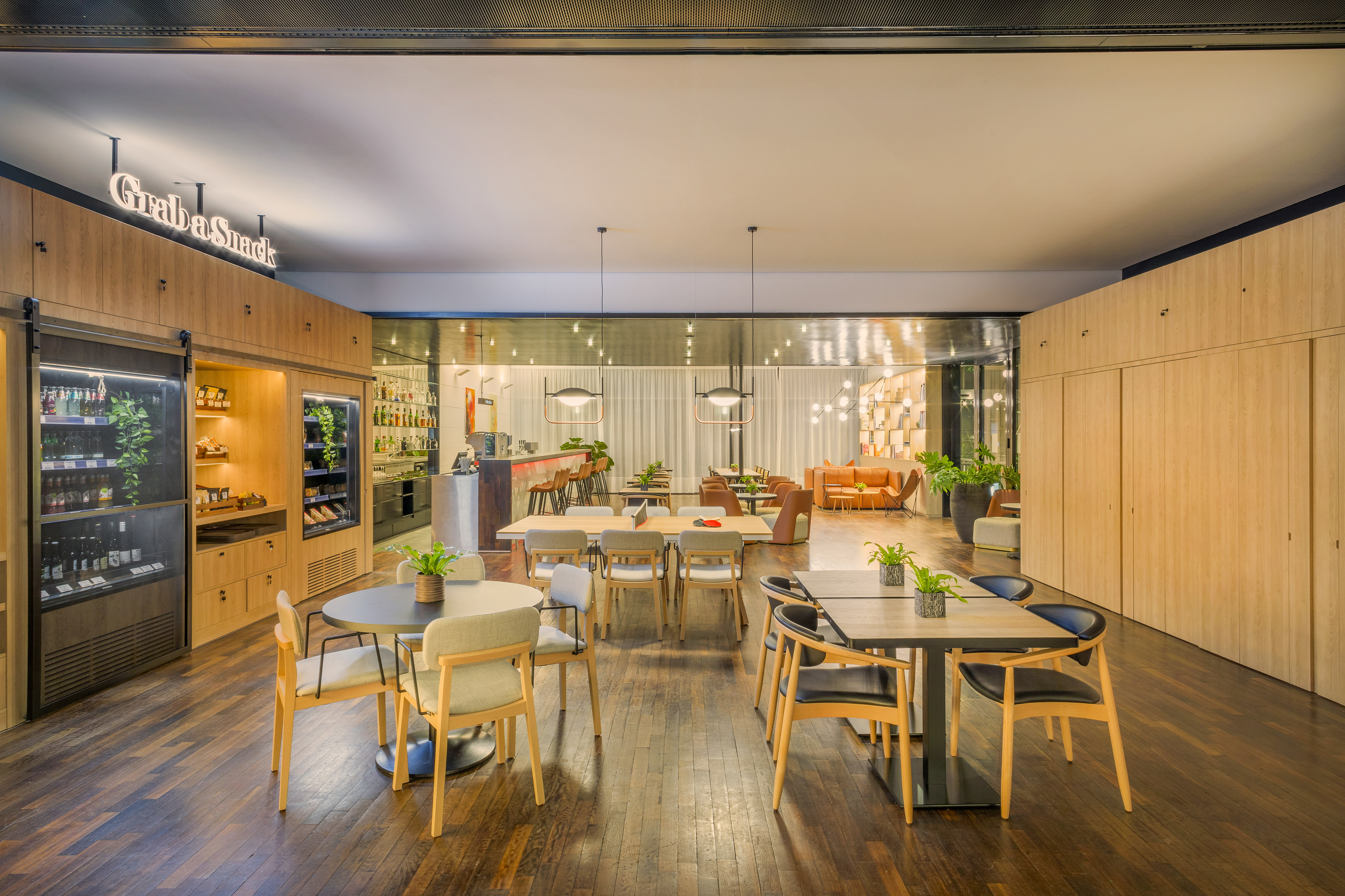 Modern interior with 'Grab a Snack' bar, cafe tables, and lounge seating.