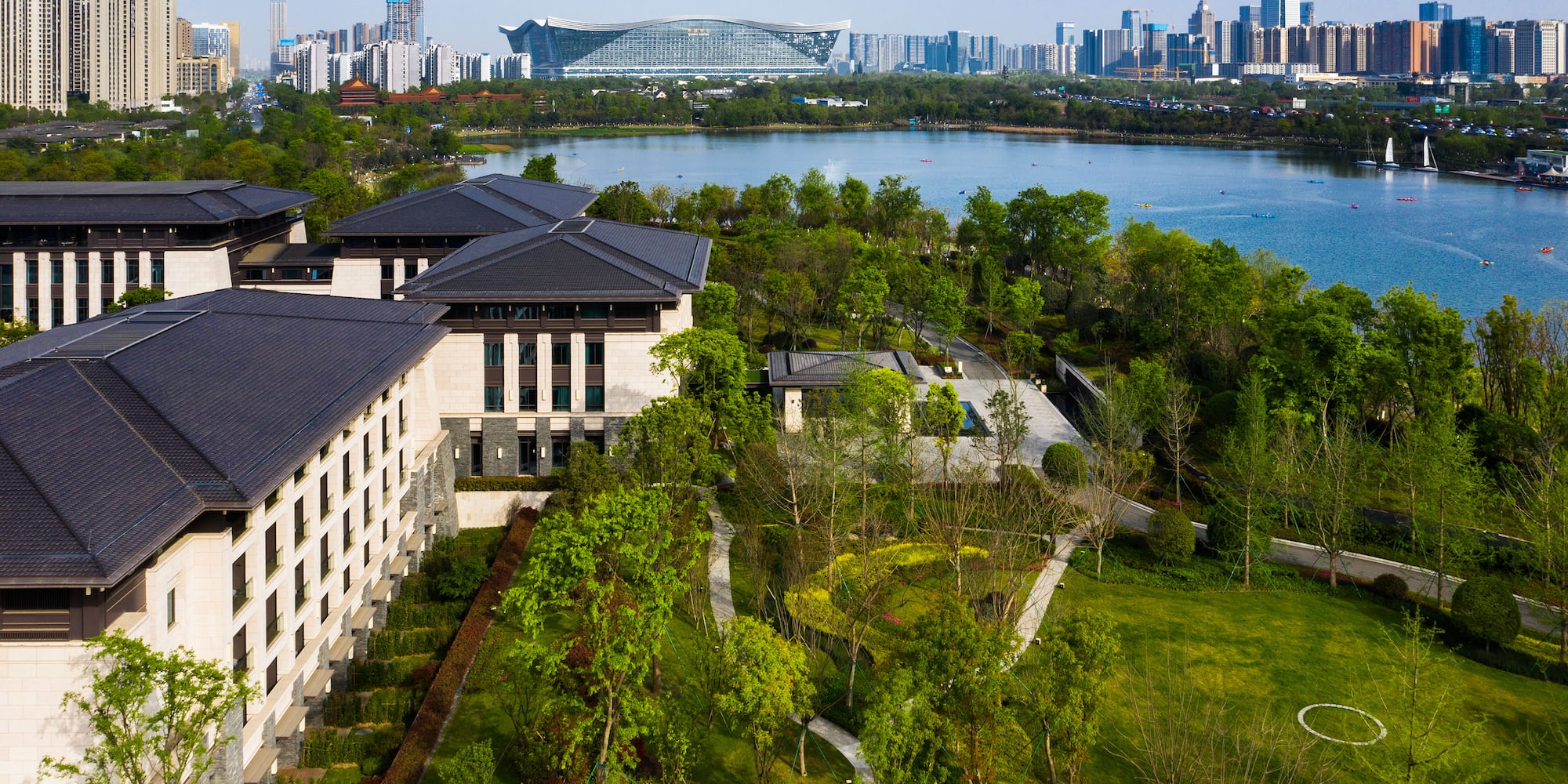 a large building with trees and a body of water
