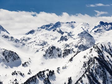 a snowy mountain tops with trees