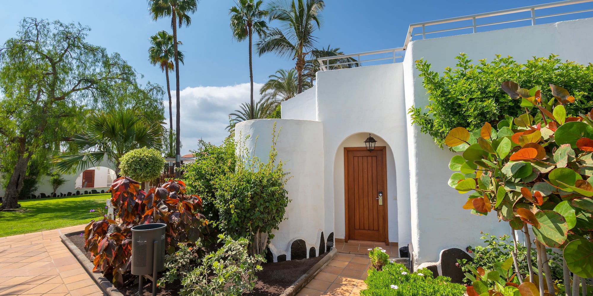 a white building with a door and trees