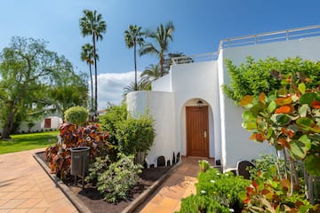 a white building with a door and trees