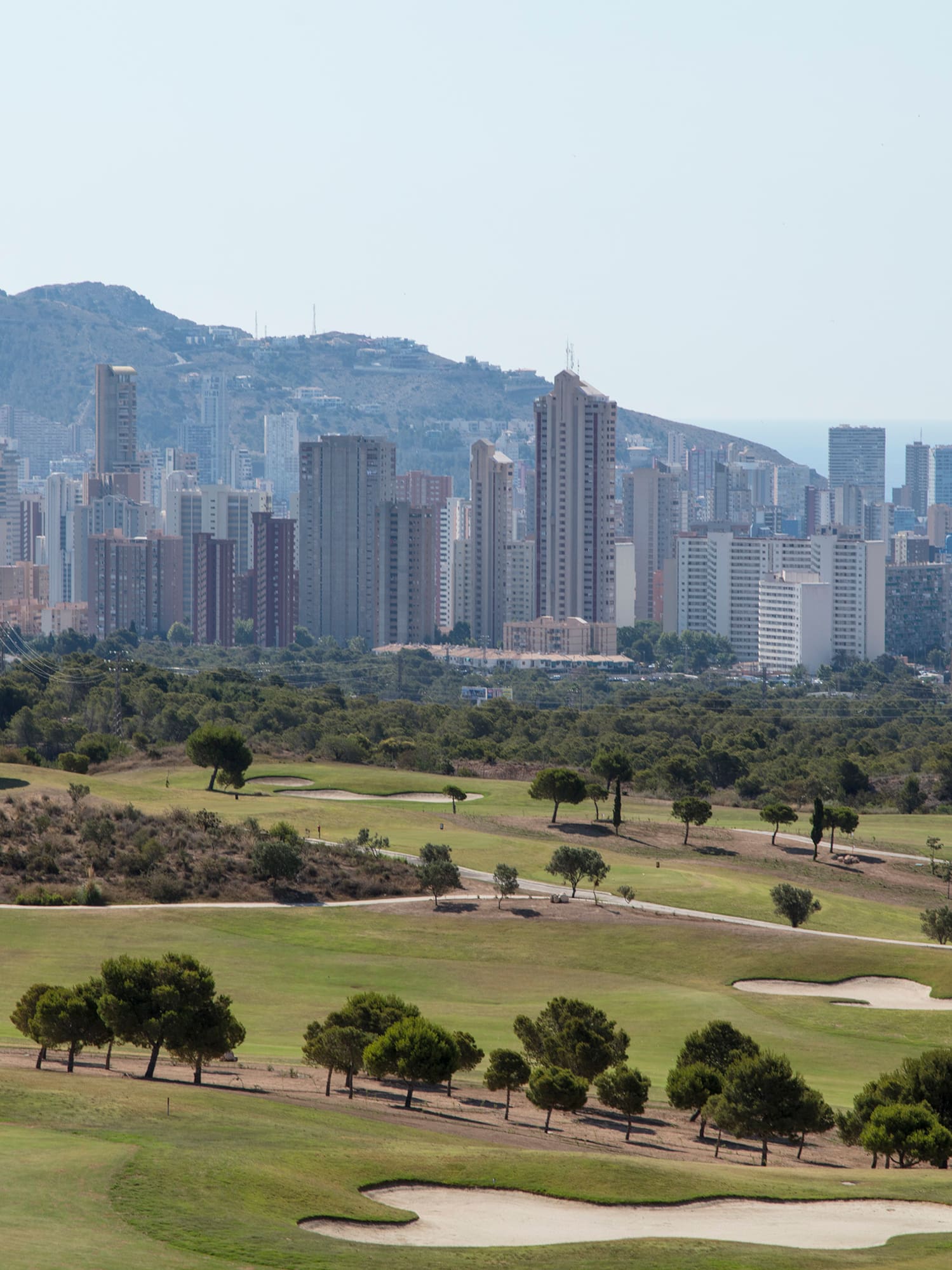 a golf course with a city in the background