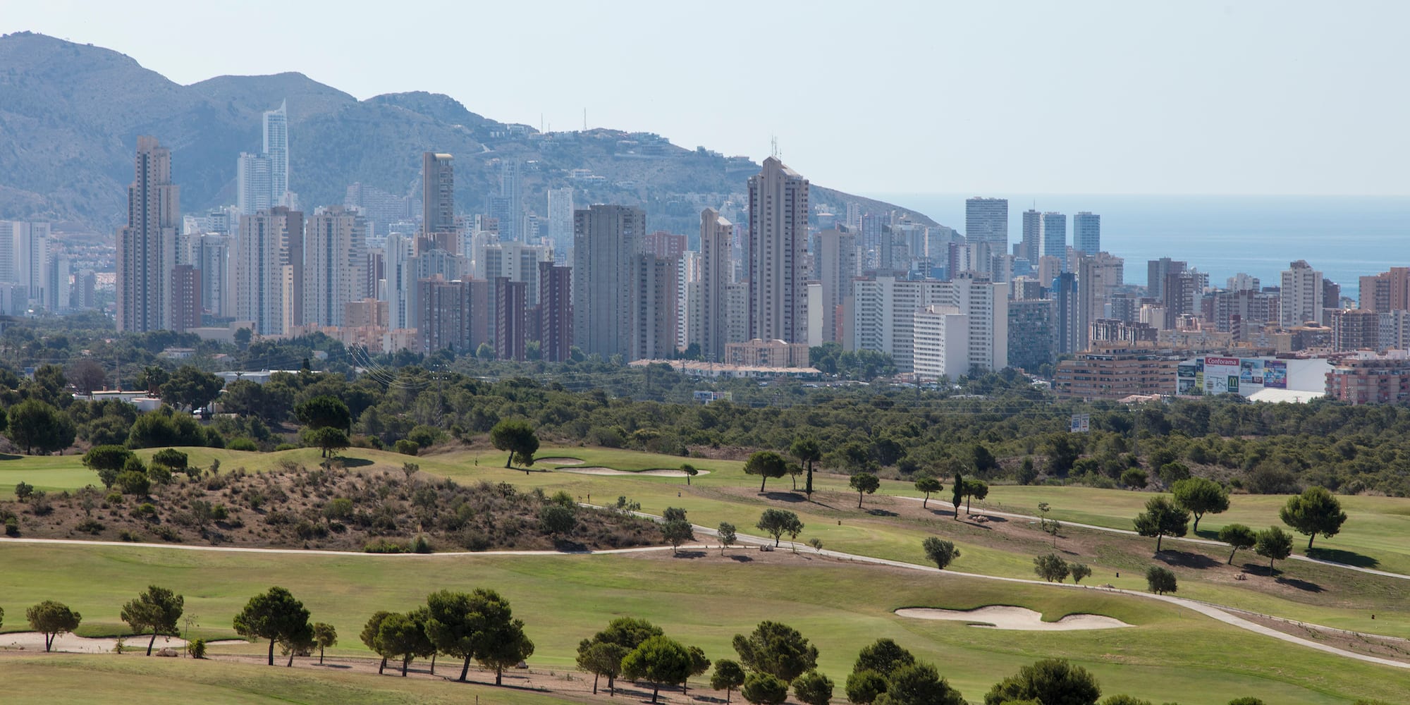 a golf course with a city in the background