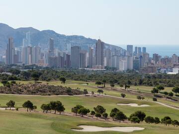 a golf course with a city in the background