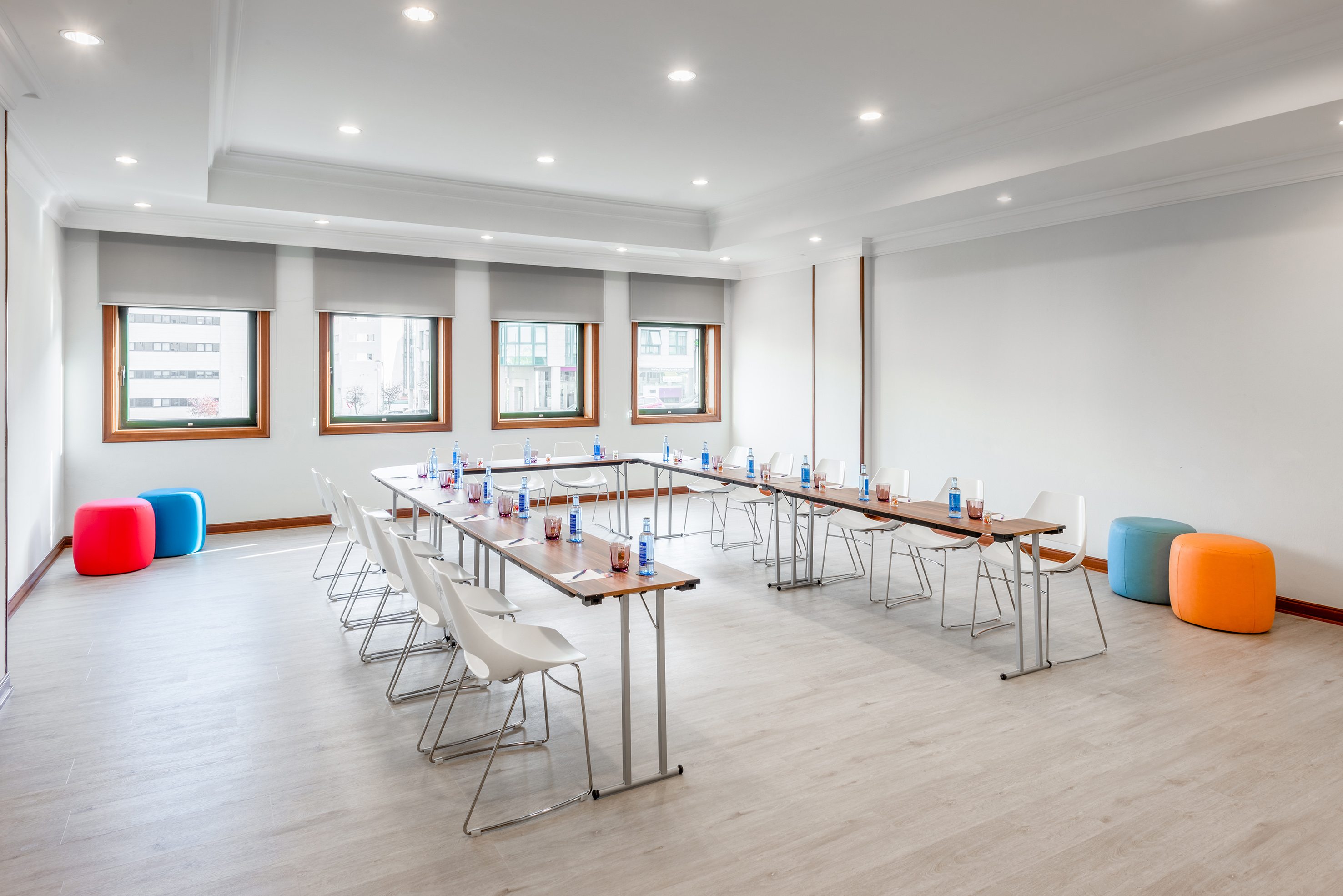 Modern U-shaped meeting room with white chairs, tables, and natural light. - Lugo - Hotel Santiago Plaza Affiliated by Meliá, Santiago de Compostela