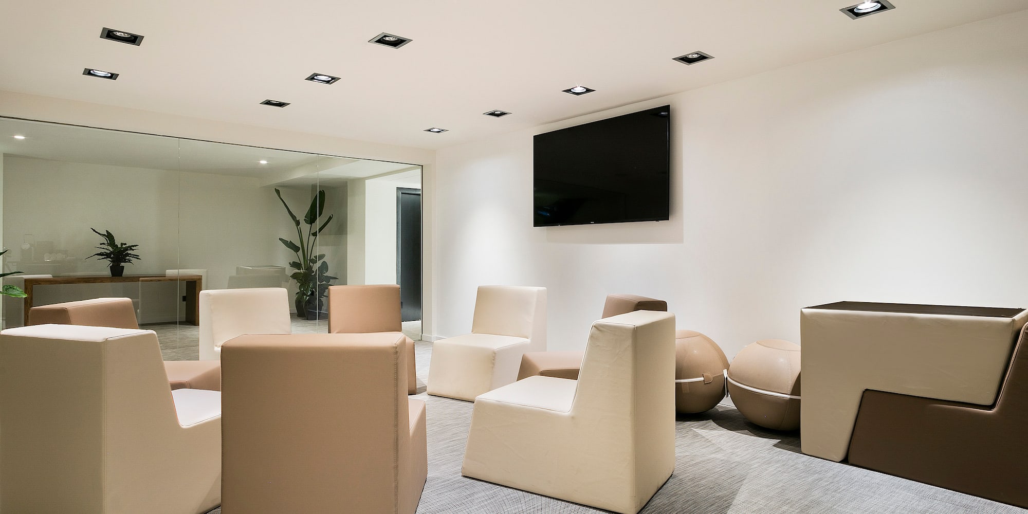 a room with white chairs and a television