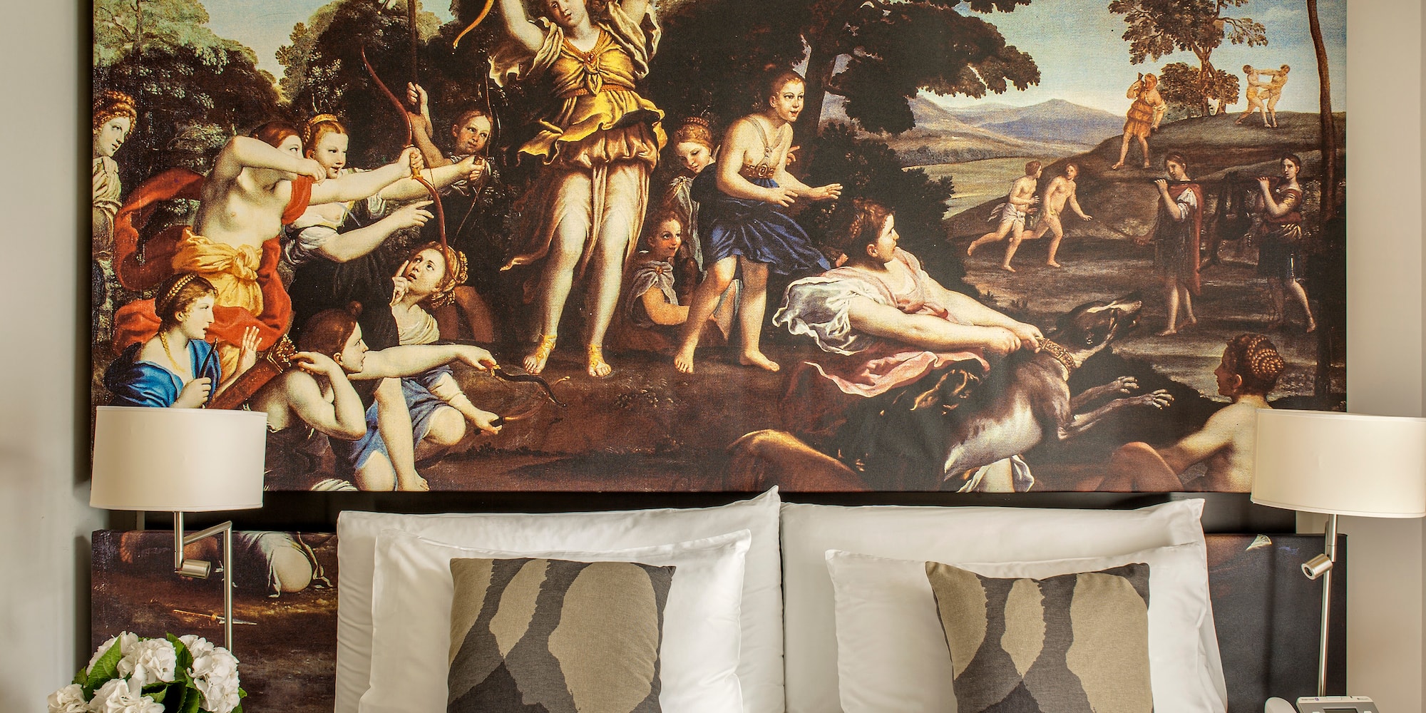 a bed with a painting above it