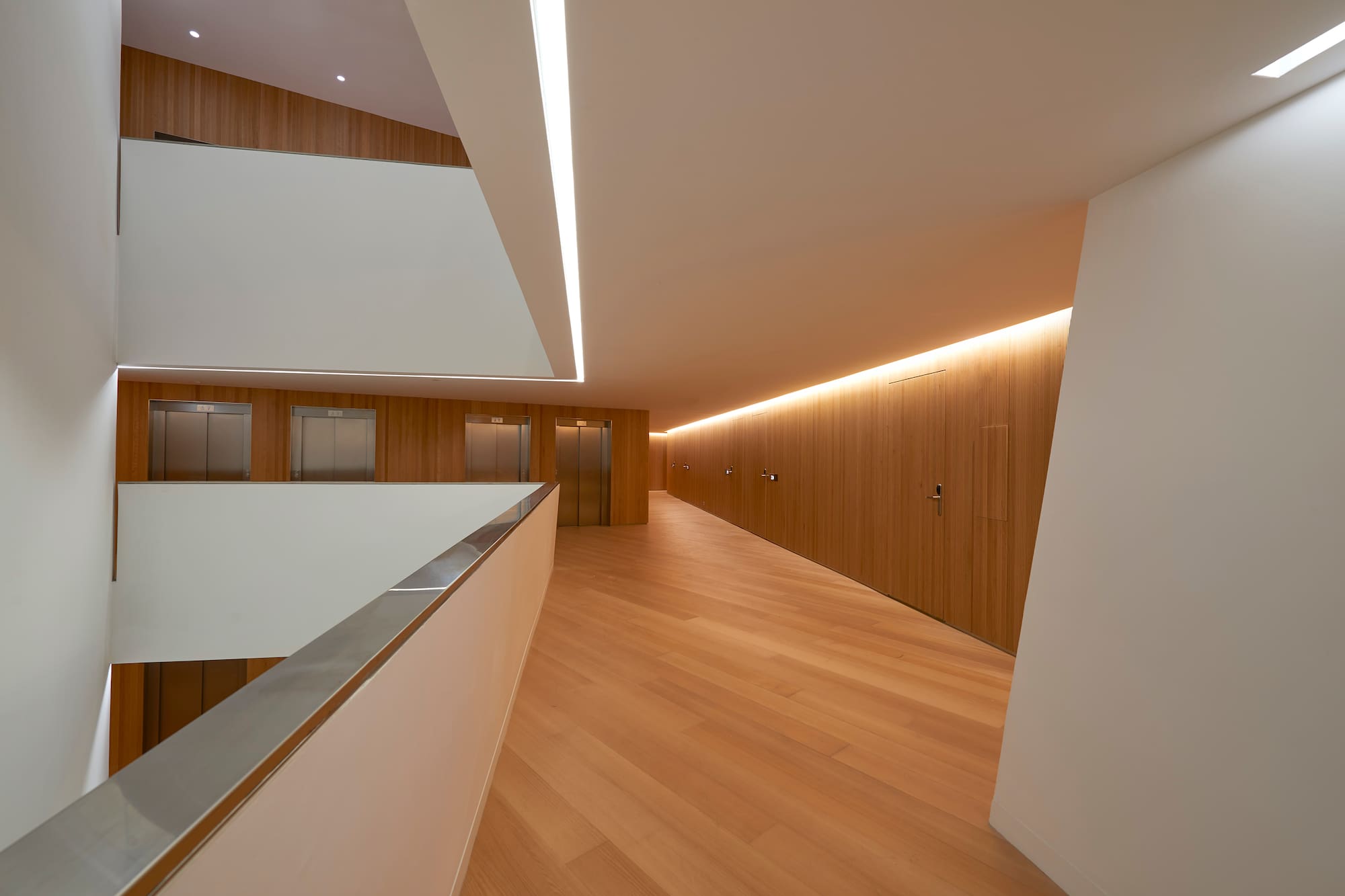 a hallway with wooden floors and a white wall