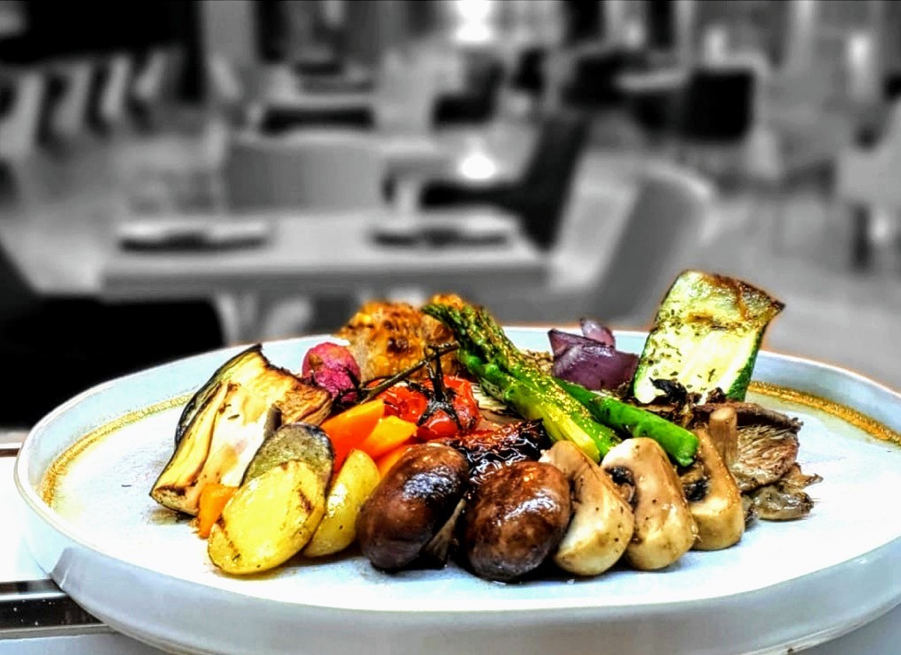 Assorted roasted vegetables on a plate: mushrooms, asparagus, zucchini. Restaurant food.