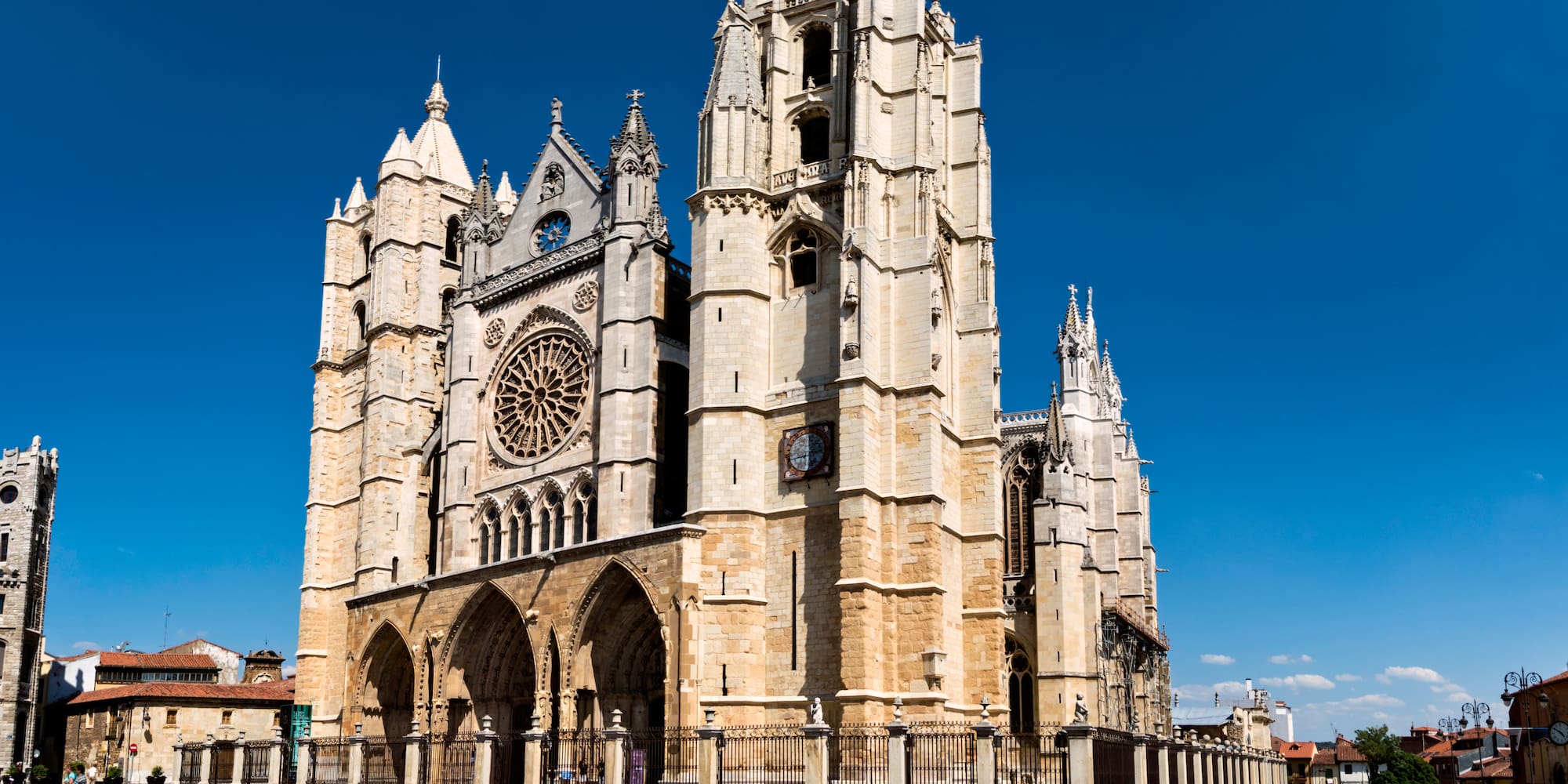 a large stone building with a clock tower with León Cathedral in the background