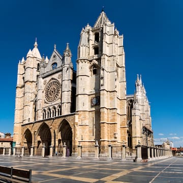 a large stone building with a clock tower with León Cathedral in the background