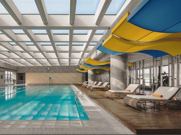 a swimming pool with lounge chairs and a large ceiling