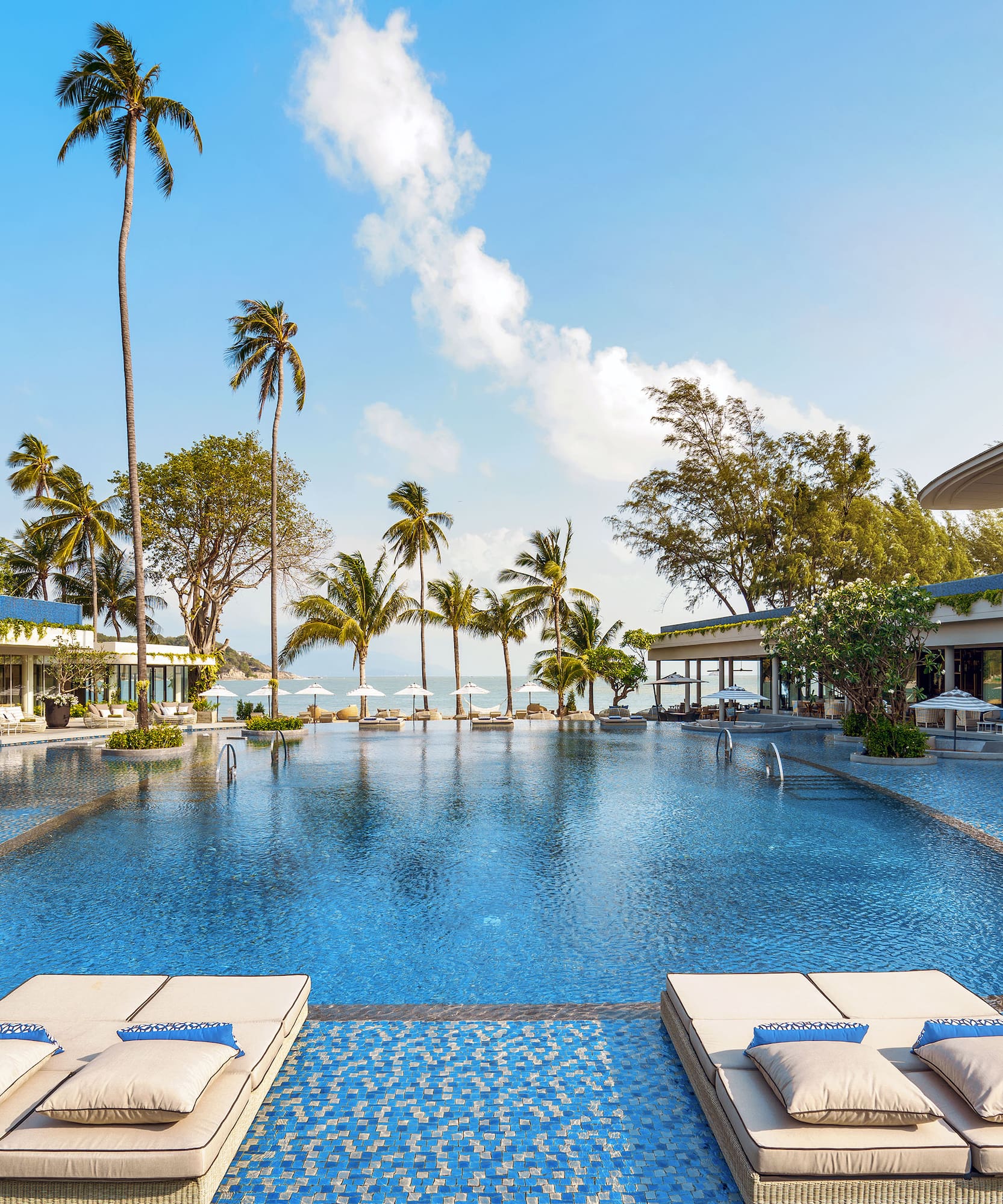 a swimming pool with lounge chairs and palm trees