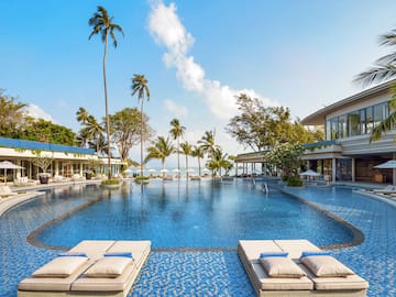 a swimming pool with lounge chairs and palm trees