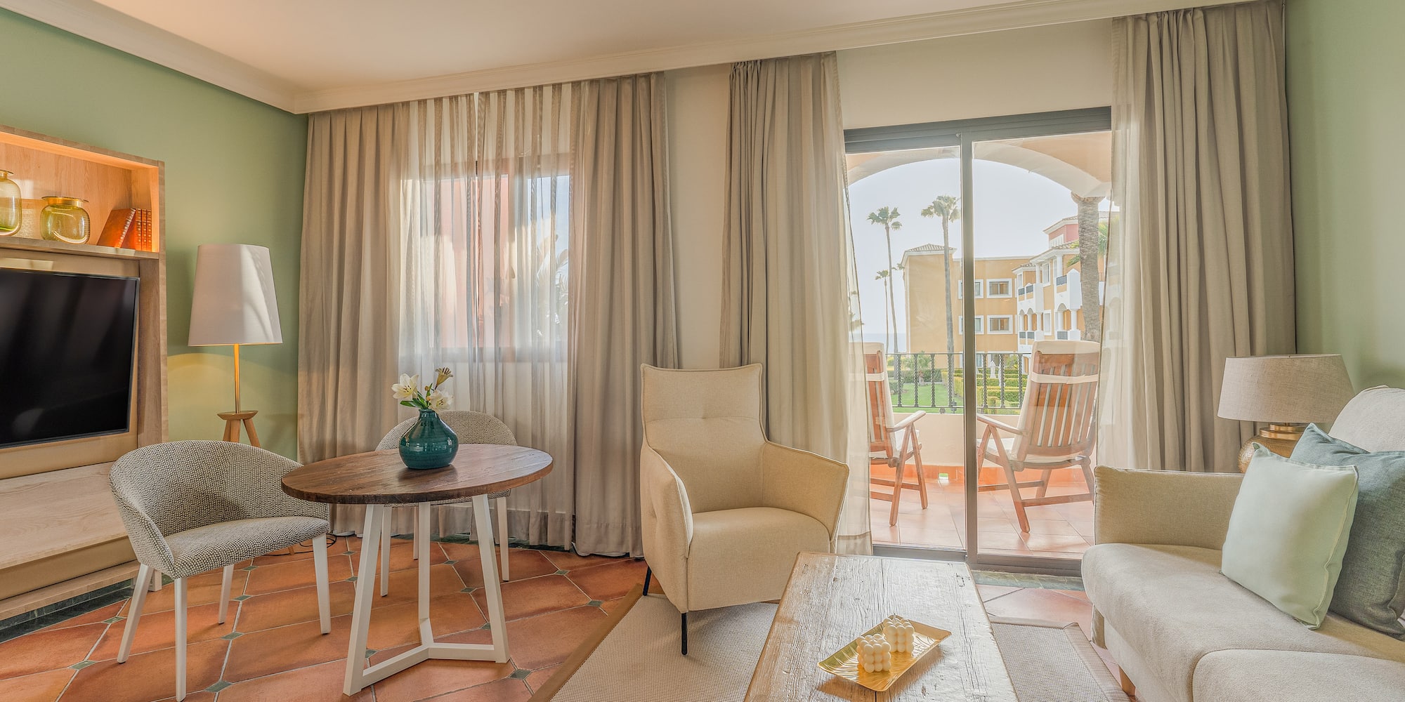a living room with a glass door and a table and chairs