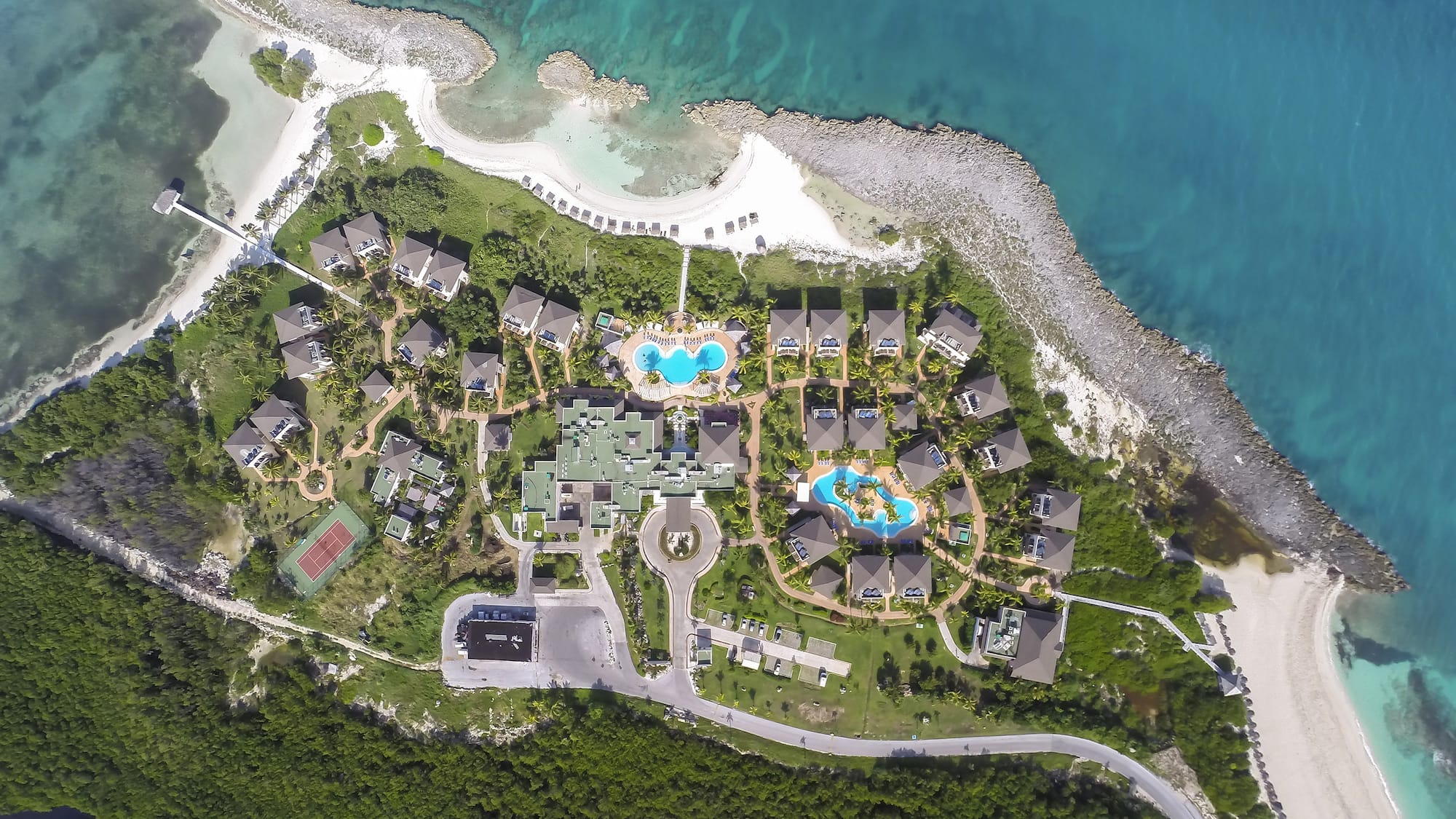 a aerial view of a resort with a pool and a body of water