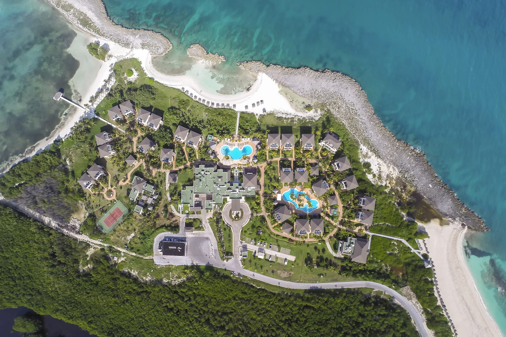 a aerial view of a resort with a pool and a body of water