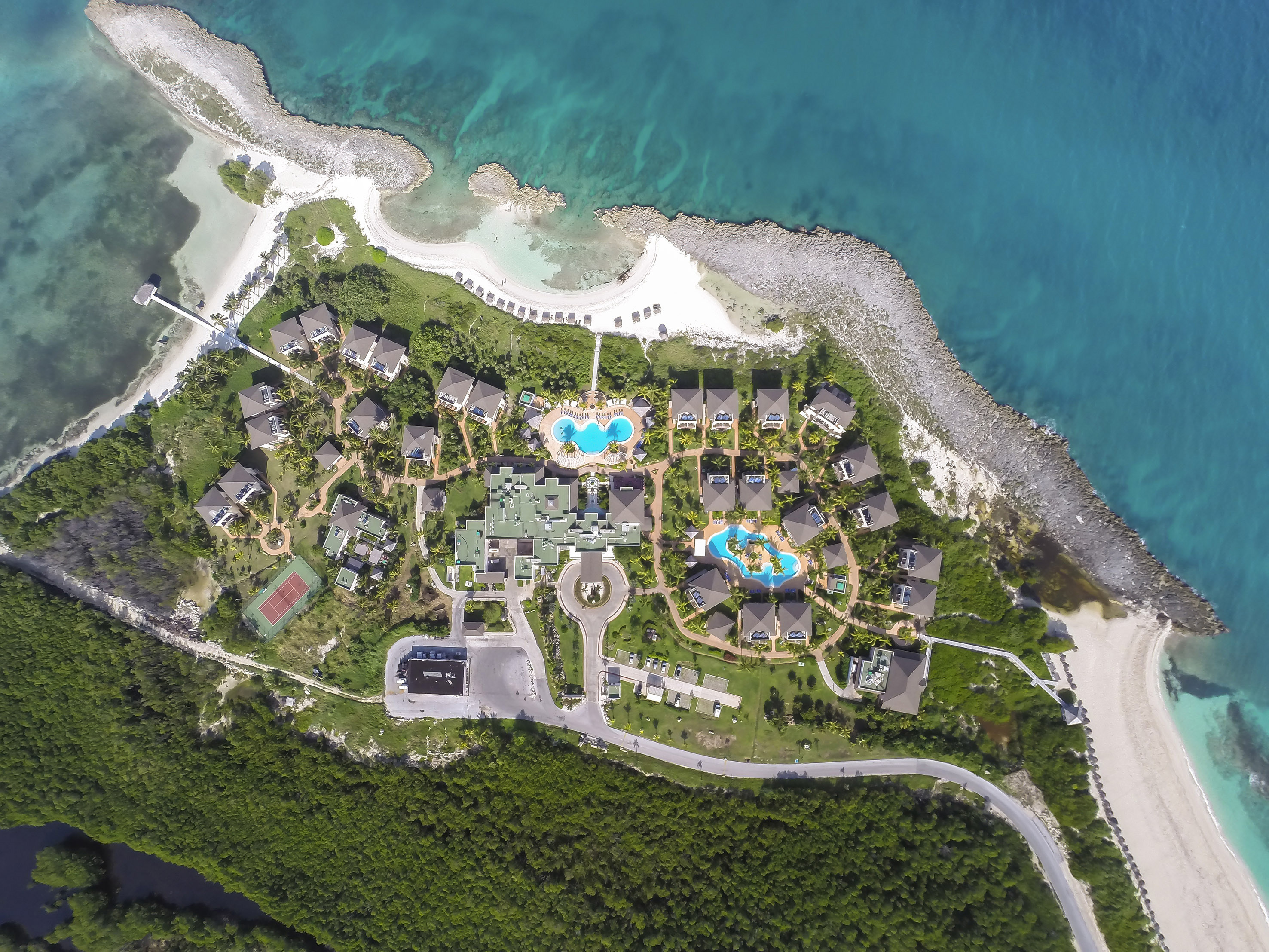 a aerial view of a resort with a pool and a body of water
