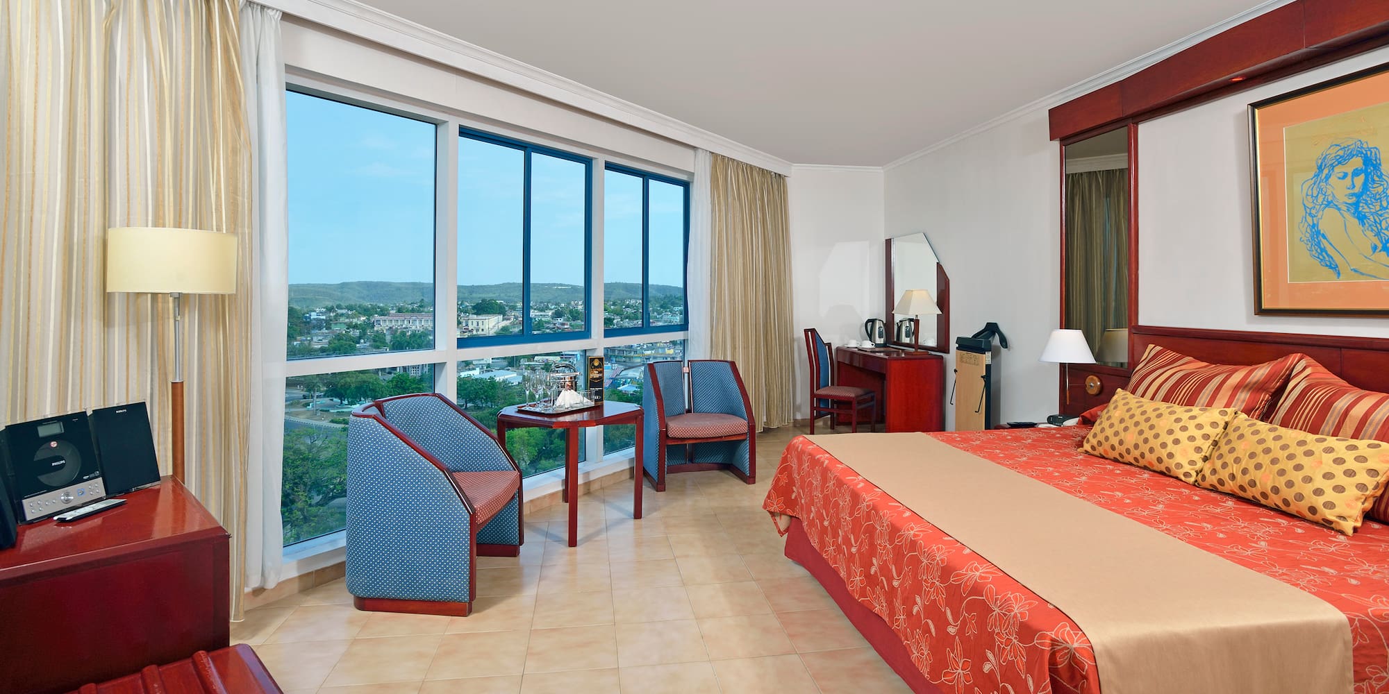 a room with a bed and chairs