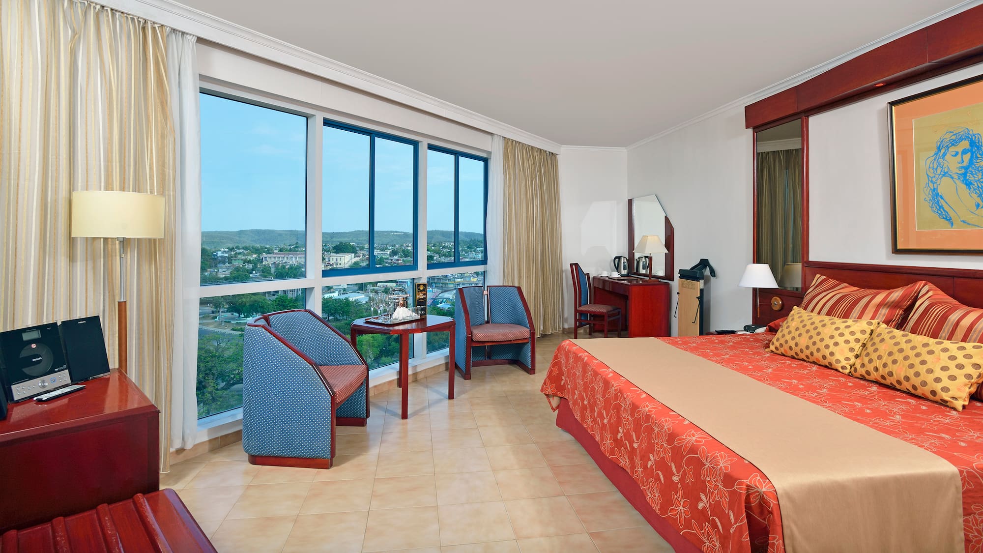 a room with a bed and chairs