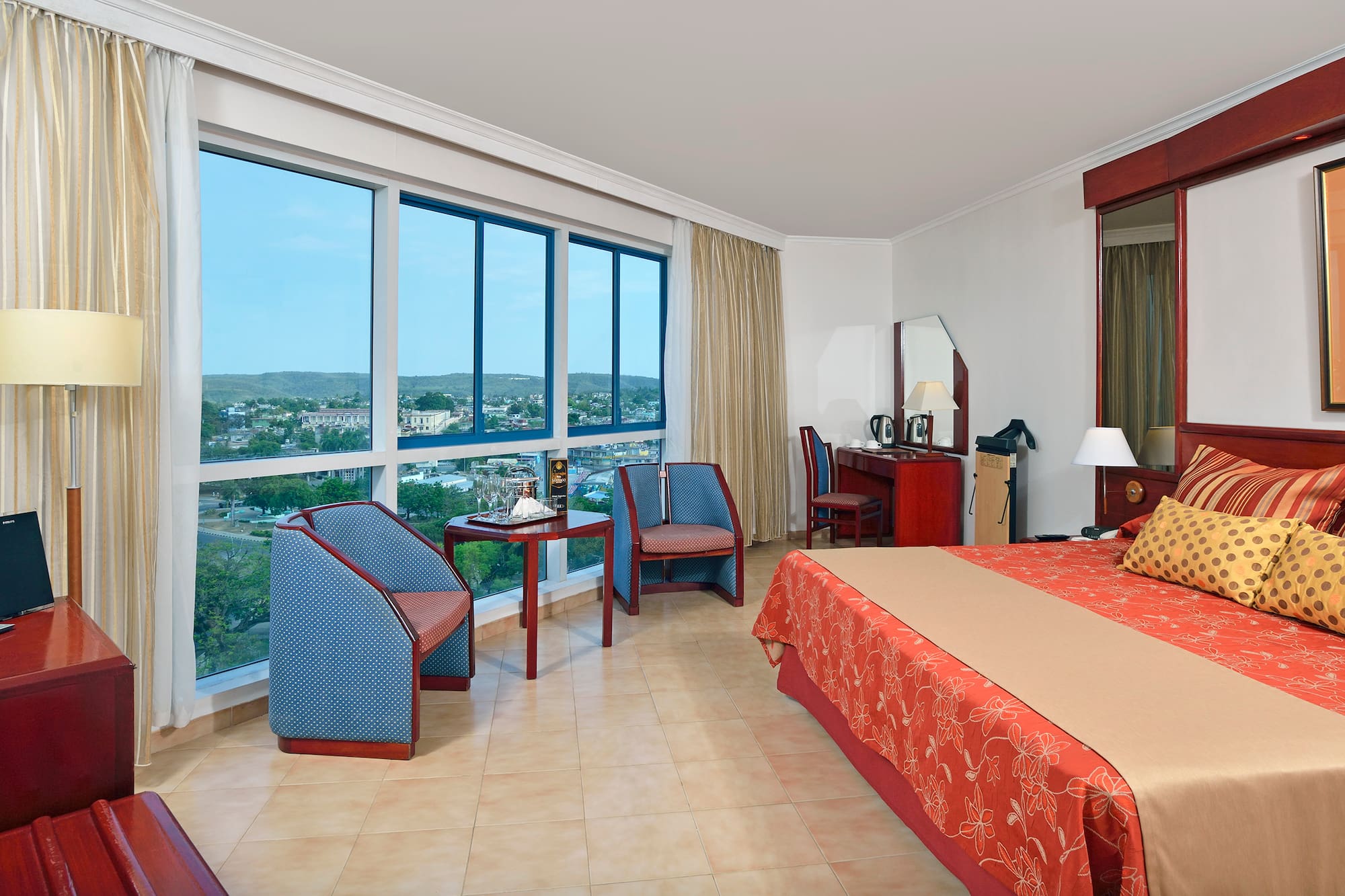 a room with a bed and chairs