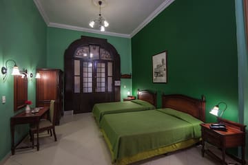a room with green walls and a bed and a table