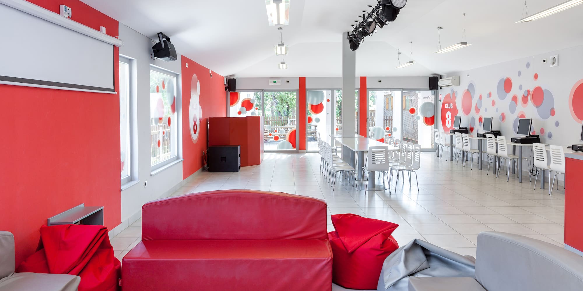 a room with red couches and chairs