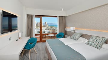 a room with two beds and a table and chairs