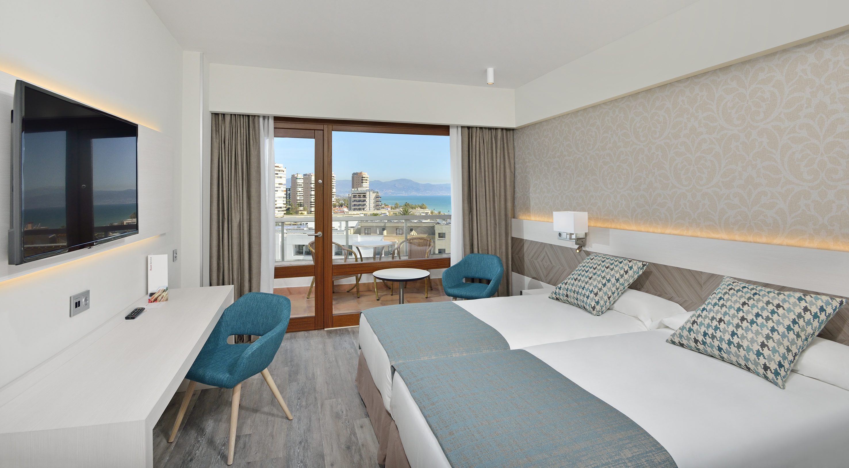 a room with two beds and a table and chairs