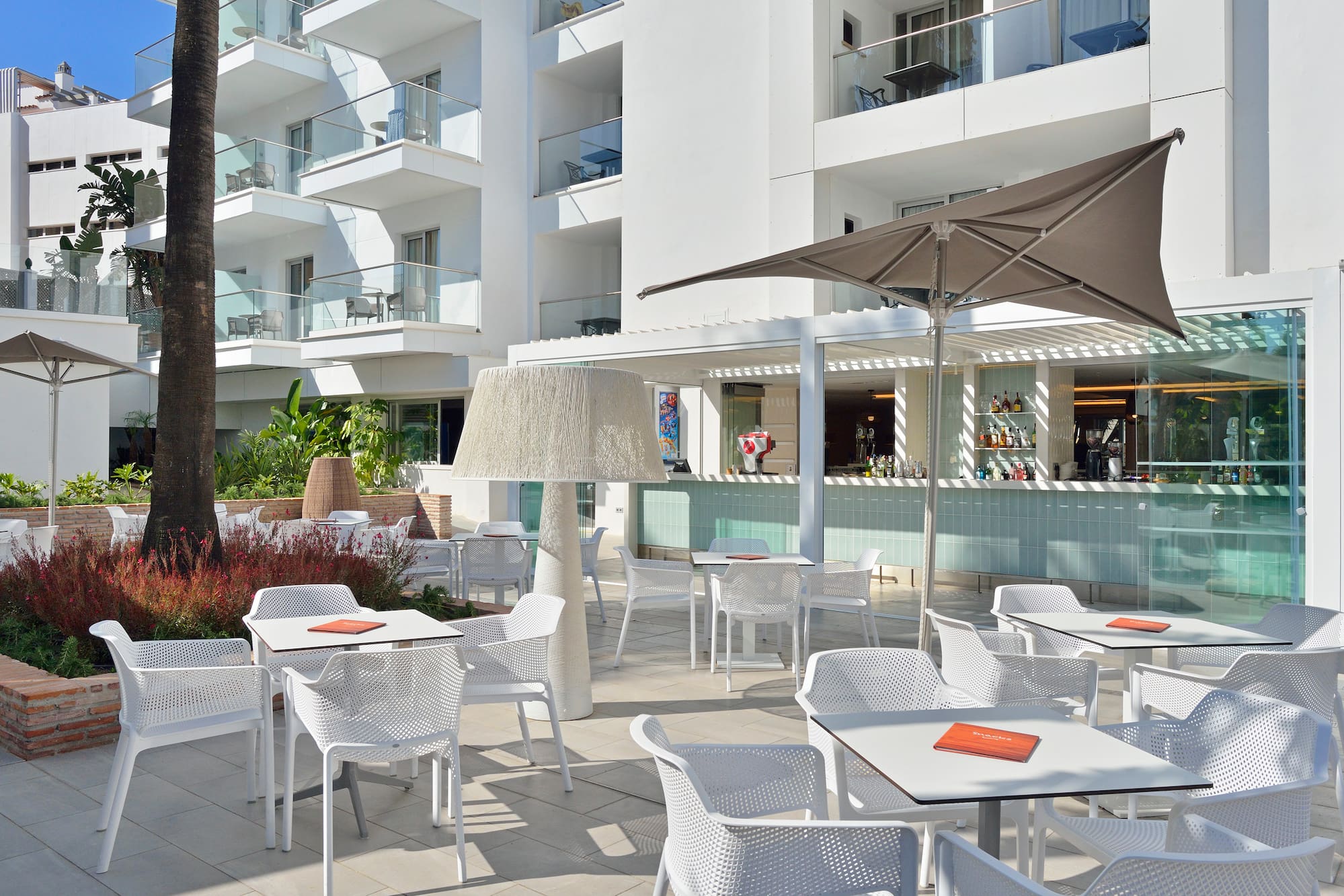 a patio with tables and chairs and umbrellas