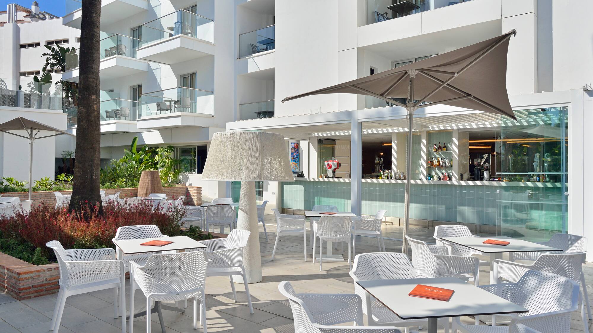 a patio with tables and chairs and umbrellas