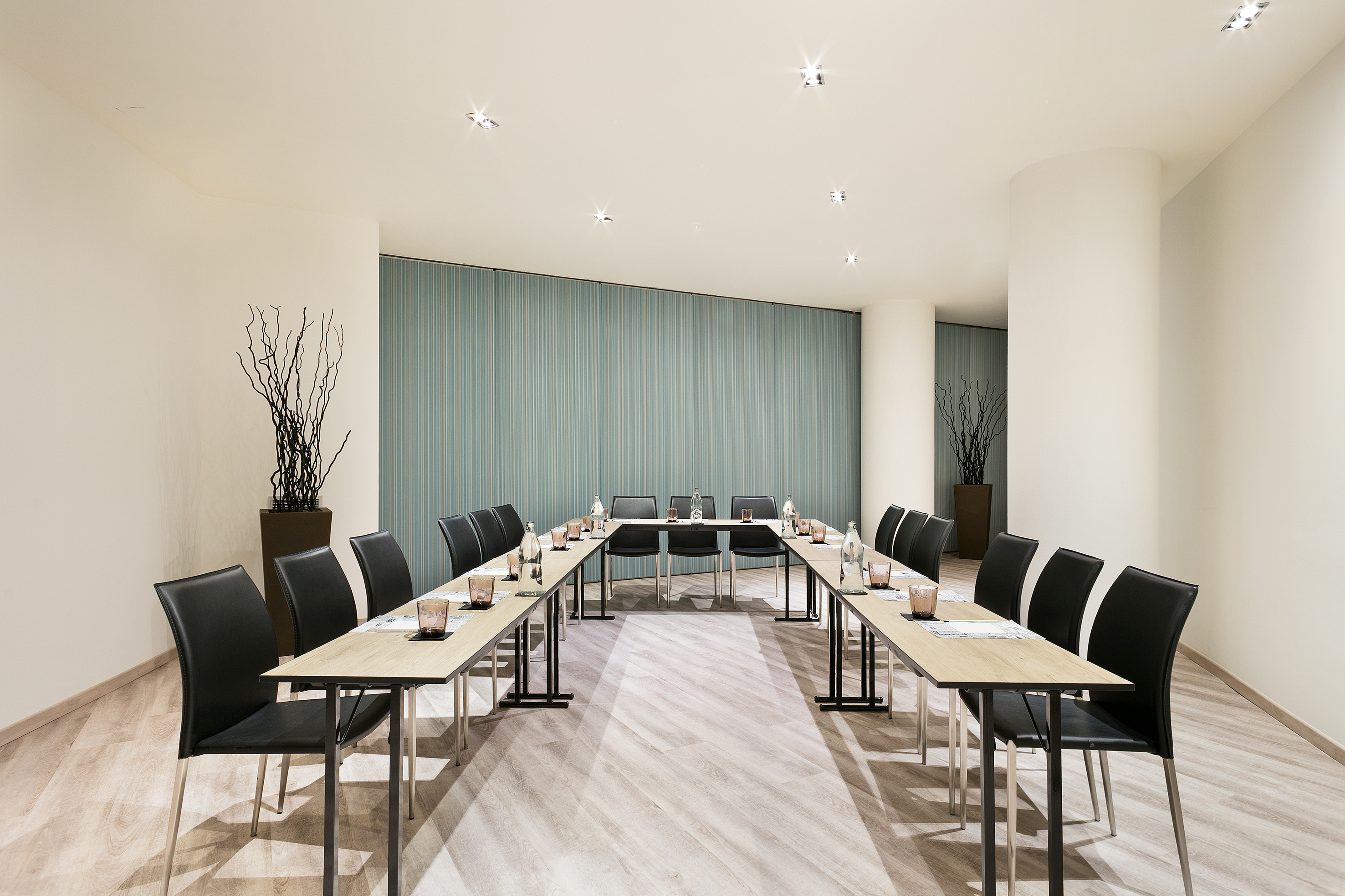 Modern U-shaped meeting room setup with black chairs, wood floor, teal wall. - POBLE NOU - فندق برشلونة كوندال مار(Condal Mar) المنتسب لـ Melia, برشلونة