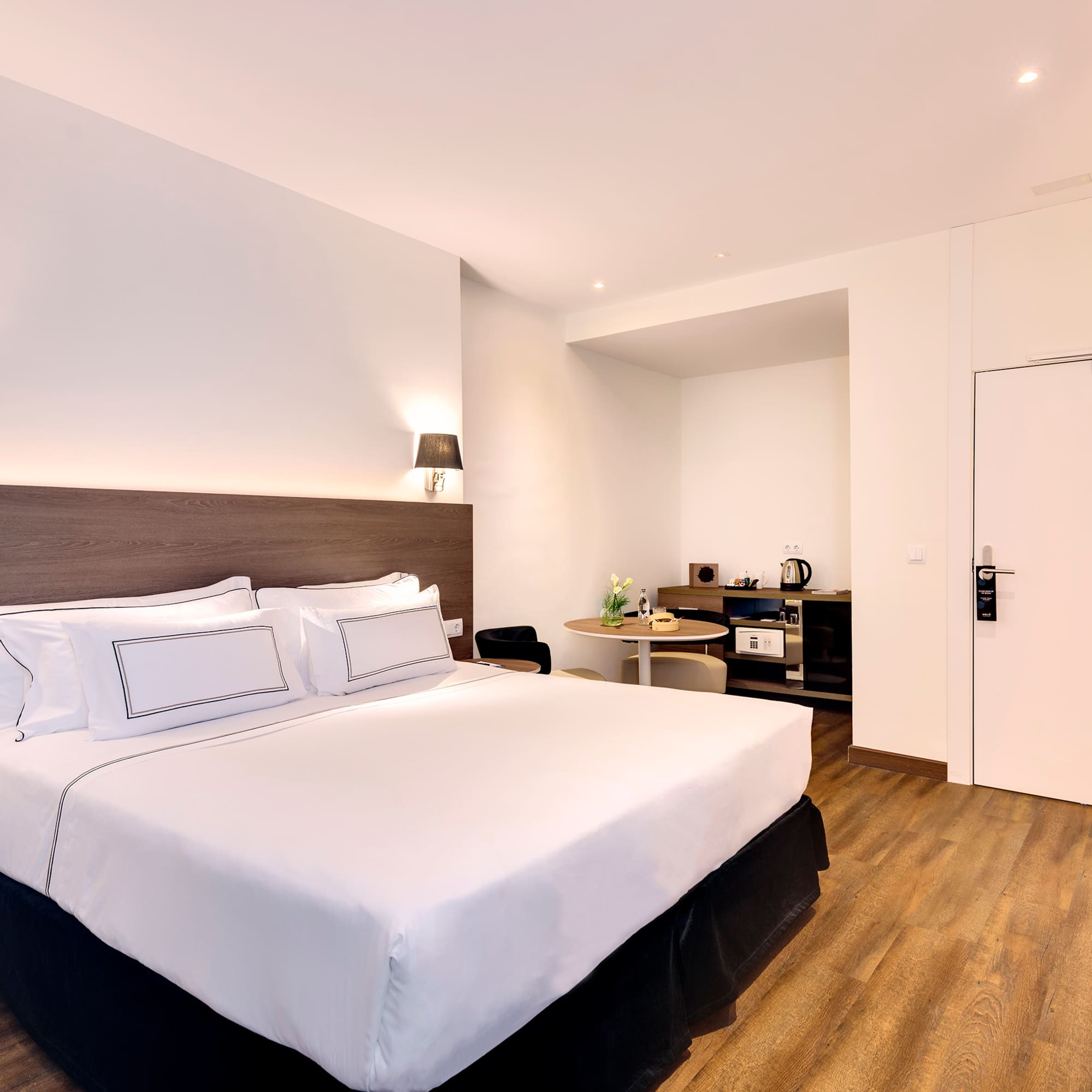 a bed with white sheets and a wood floor