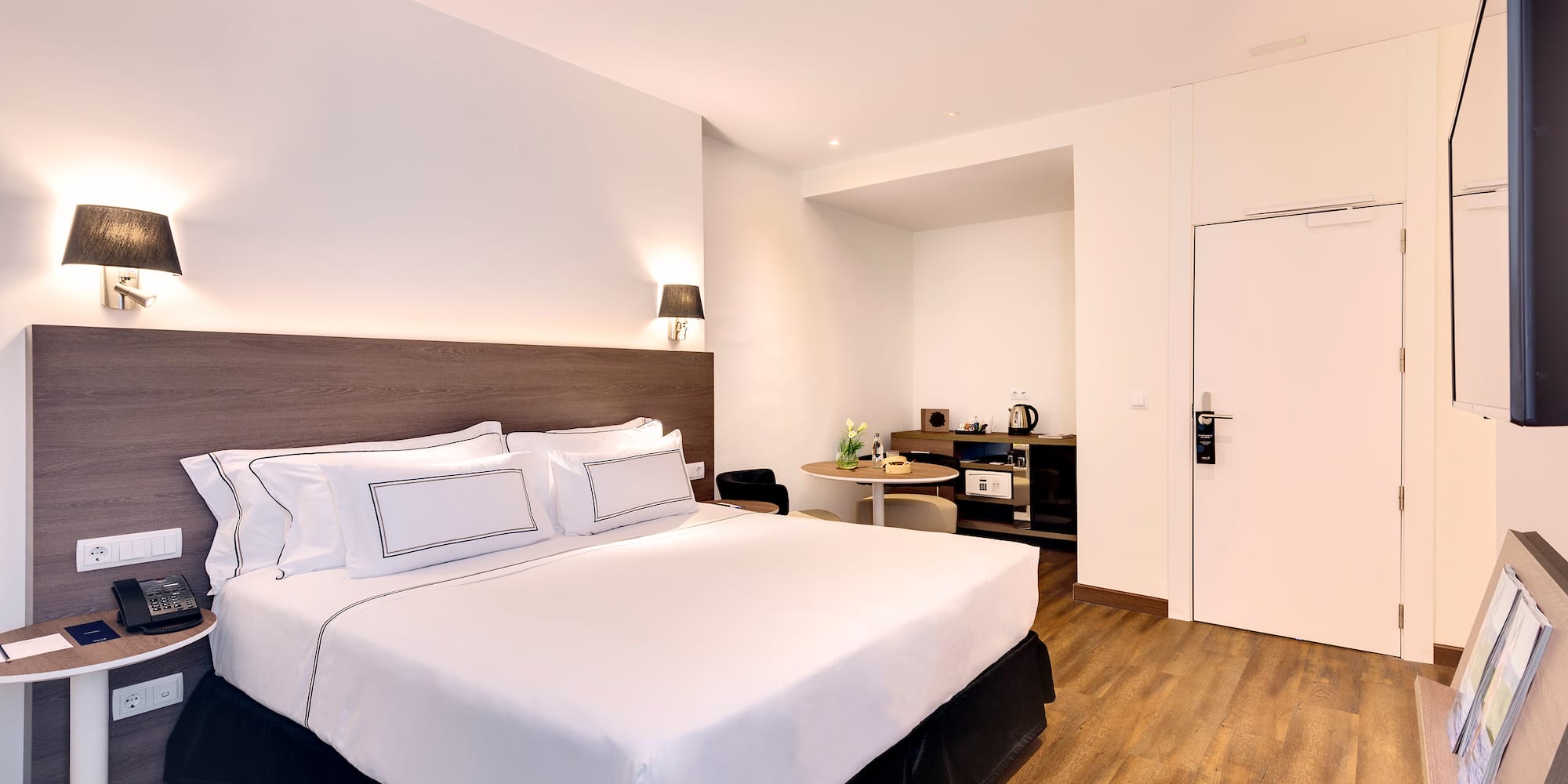 a bed with white sheets and a wood floor