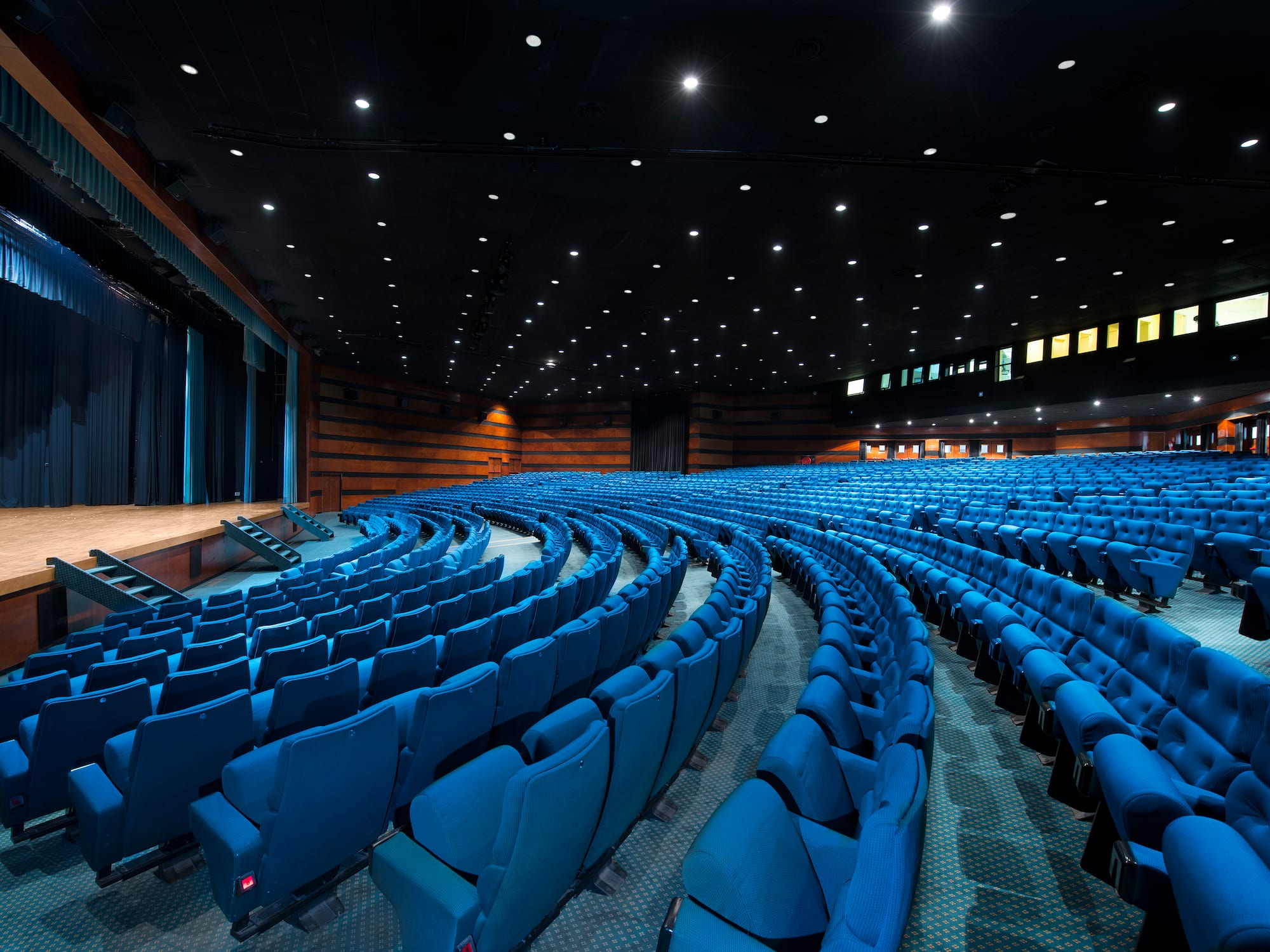 a large auditorium with blue chairs